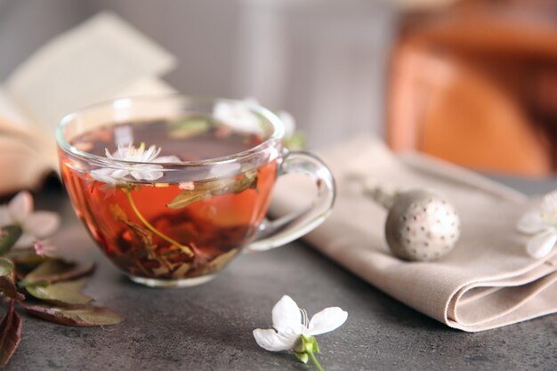 Cup of tea with flowers on brown table