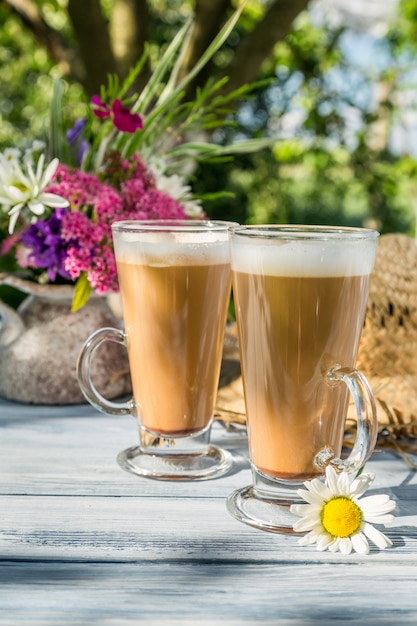 木製のテーブルの上に花とお茶のカップ