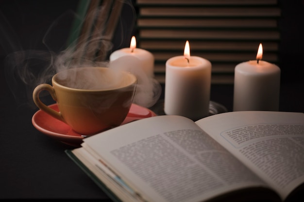 Cup of tea with hot smoke and lit candle on the desk at home\
power outage