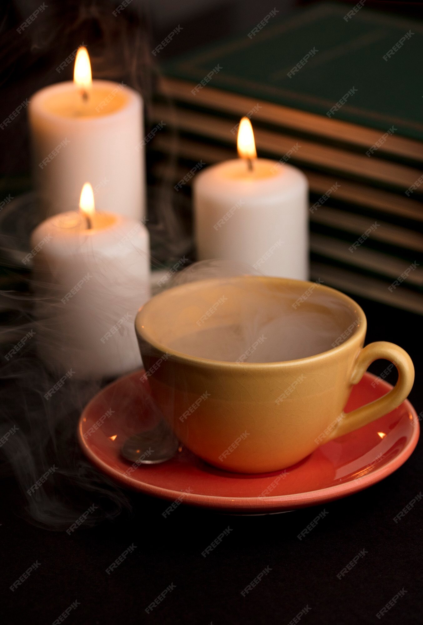Premium Photo  Cup of tea with hot smoke and three burning candles on the  desk at home power outage