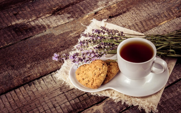 Cup of tea with lavender and cookies on a wooden table