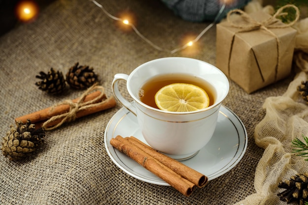 A cup of tea with lemon on a burlap.