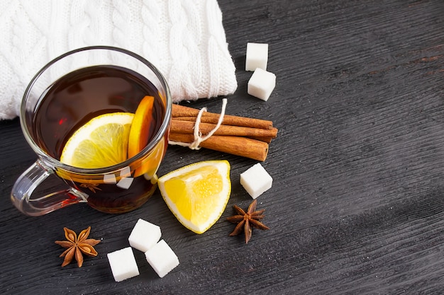 Cup of tea with lemon, cinnamon, knitted rug. 