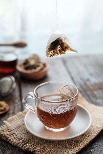 A cup of tea with lemon and honey for breakfast Served in glass on wooden table Selective focus