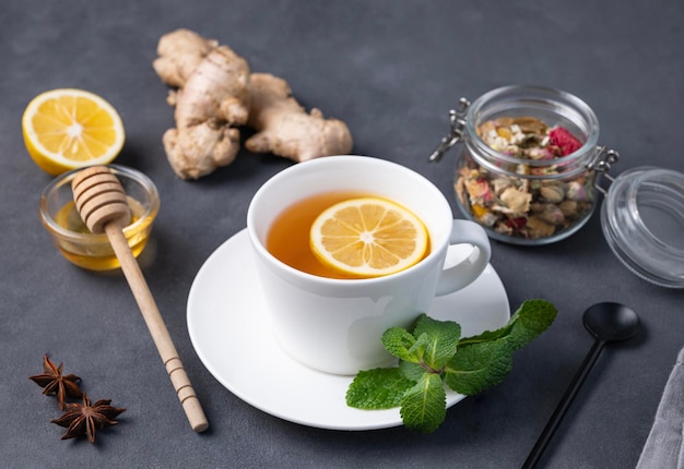 Cup of tea with lemon honey on a dark background The concept of a healthy drink for immunity