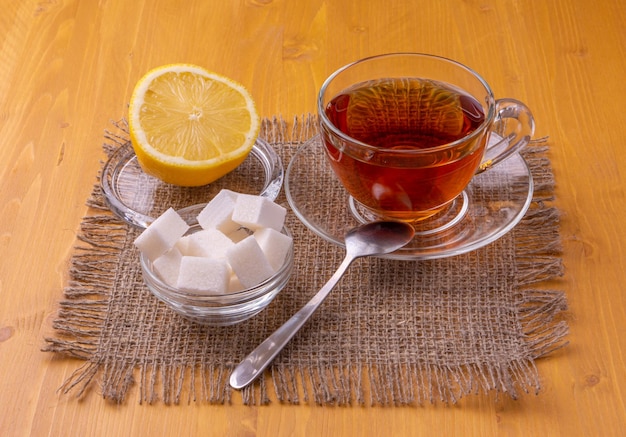 A cup of tea with lemon and sugar on a table