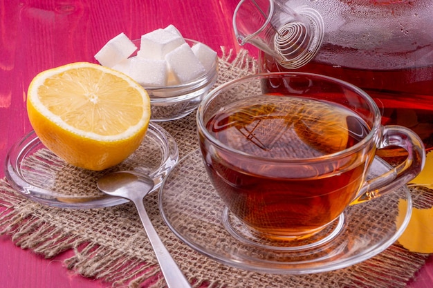 A cup of tea with lemon and sugar on a table