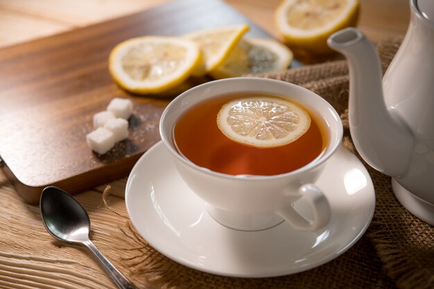 Cup of tea with lemon on wooden table