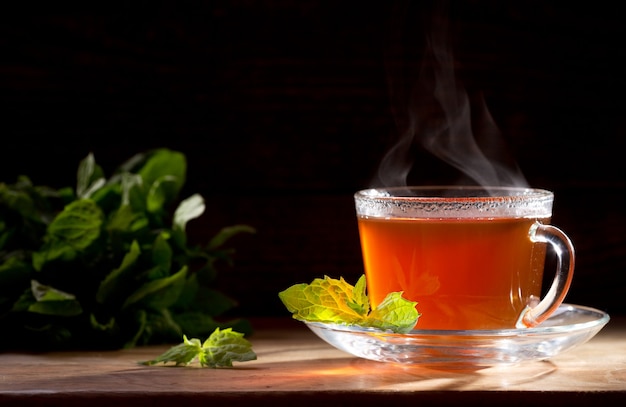 Cup of tea with mint on a wooden table