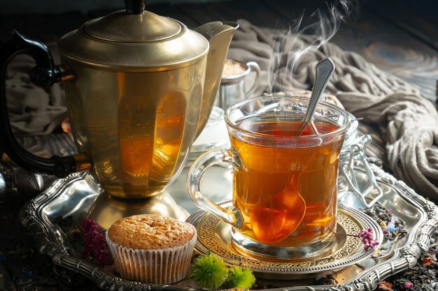 A cup of tea with a muffin on a tray