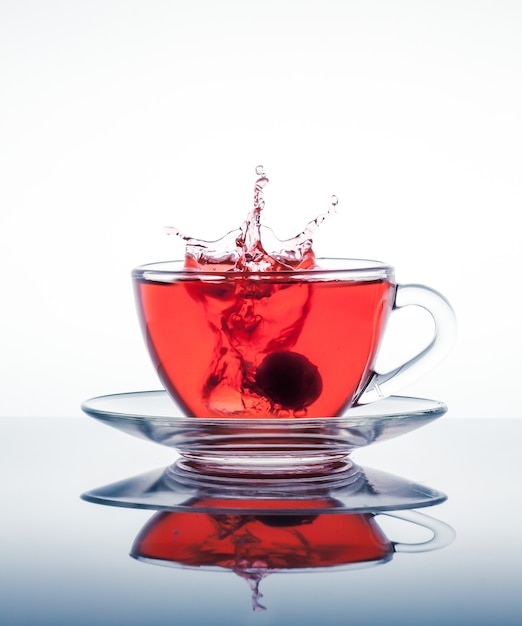 Foto tazza di tè con schizzi sulla superficie dello specchio