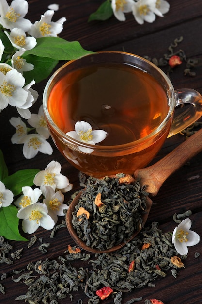 A cup of tea with a spoon and a spoon with a flower on it.