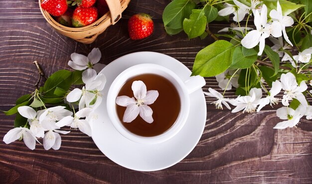 Cup of tea with white apple blossoms