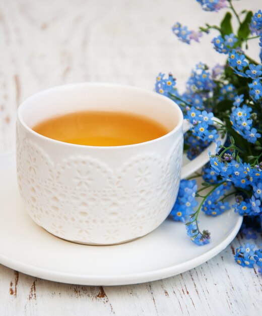 Cup of teand forget me not flowers