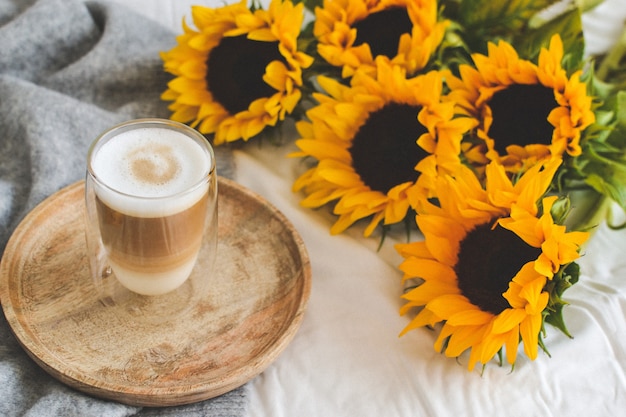 Cup with cappuccino, sunflowers, bedroom, morning concept, autumn