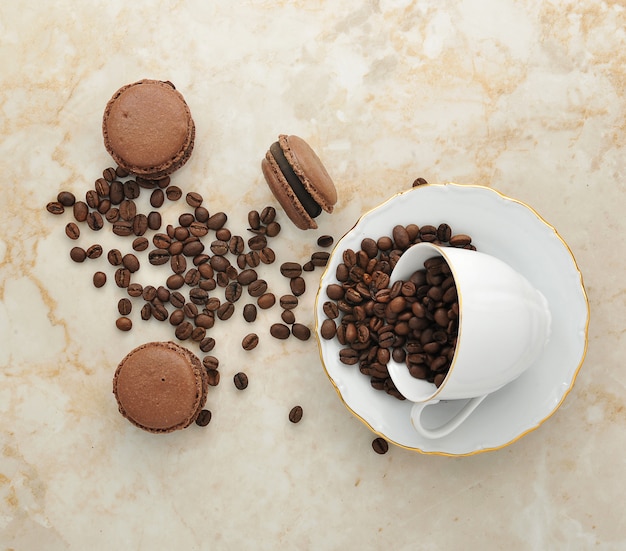 Cup with coffee beans and chocolate macarons