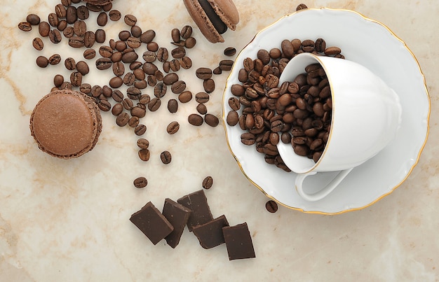 Cup with coffee beans and chocolate macarons