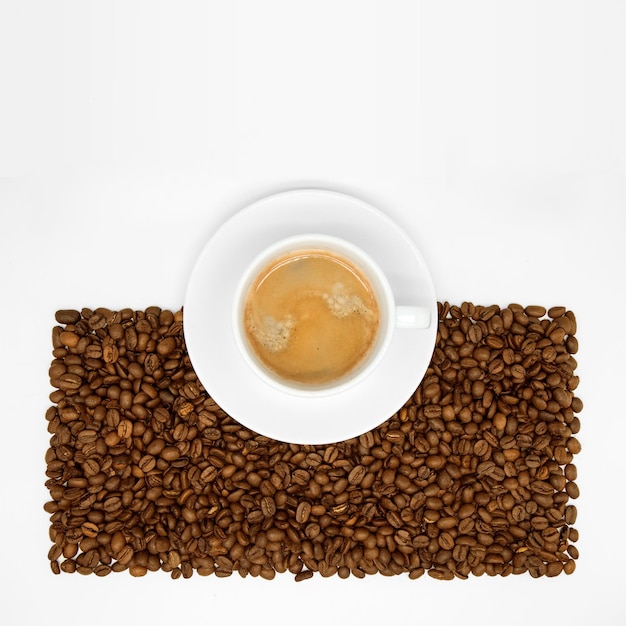 Foto tazza con caffè sui chicchi di caffè isolati su sfondo bianco