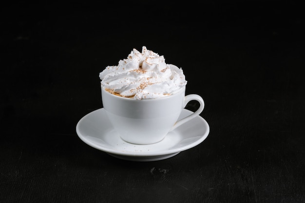 Cup with coffee and creams on black