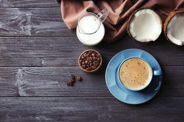 木製のテーブルにココナッツコーヒーの飲み物と材料とカップ