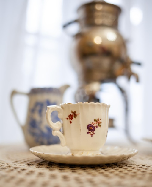 A cup with a floral design on it sits on a table.