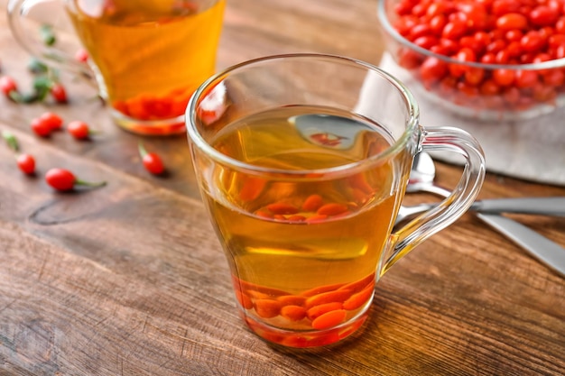 Cup with goji tea on wooden table