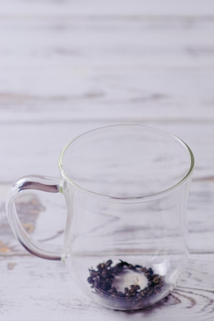 Cup with green tea and teapot on white wooden table background over light