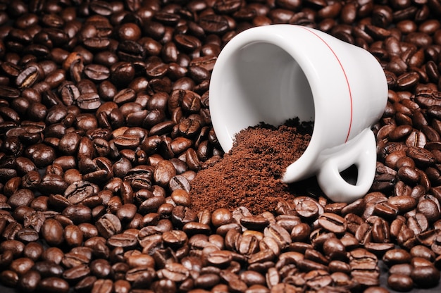 Cup with heap of coffee beans background