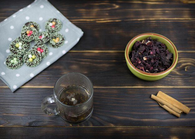 A cup with herbal tea and cookies on a dark background