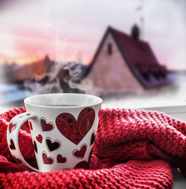 Cup with a hot drink on the windowsill 