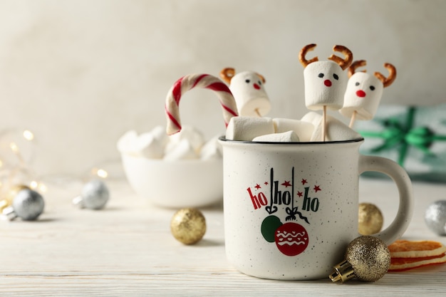 Tazza con marshmallow sulla superficie in legno di natale