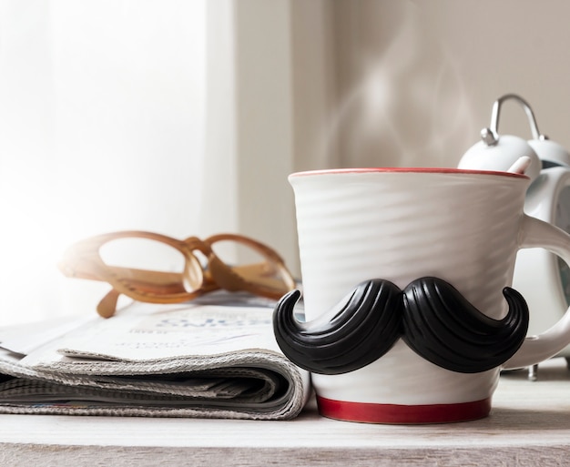 Cup with mustache on wooden table for fathers day concept