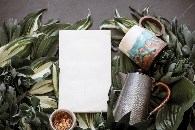 Photo cup with a teapot on a green leaf