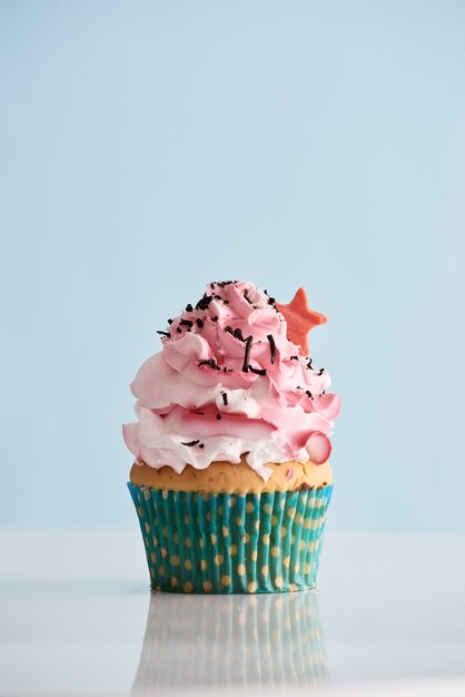 Cupcake met roze crème suikerglazuur op tafel