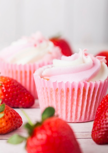 Cupcake muffin with strawberry cream dessert on wooden table with fresh strawberries