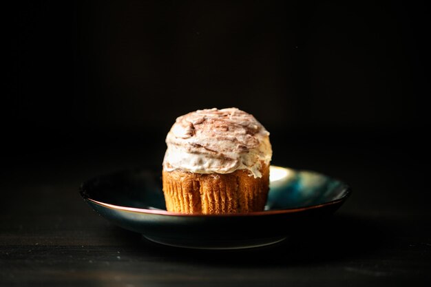 Cupcake on a plate on a black background