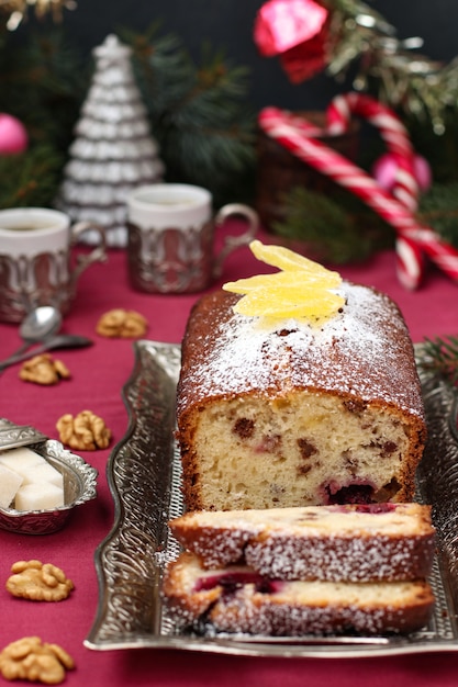 Cupcake with berries, nuts and candied fruit is located on a Christmas setting