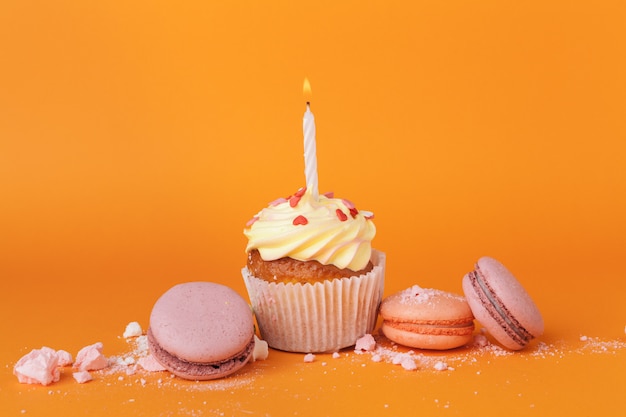 Cupcake with  birthday candles on orange