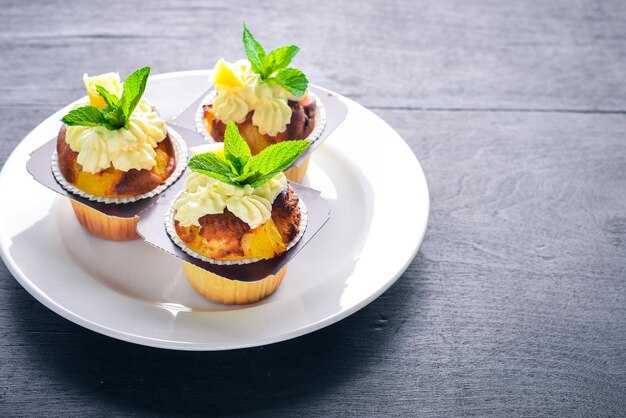 Cupcake with cream and fresh fruit On a wooden background Top view Free space for your text