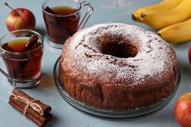 Кекс с дырочкой в центре с яблоками, бананами и корицей, посыпанный сахарной пудрой