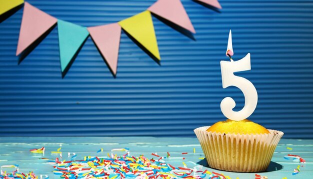 A cupcake with a number 5 on it and a blue background with flags behind it.