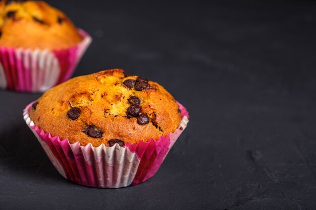 Cupcake with pieces of chocolate on a dark surface