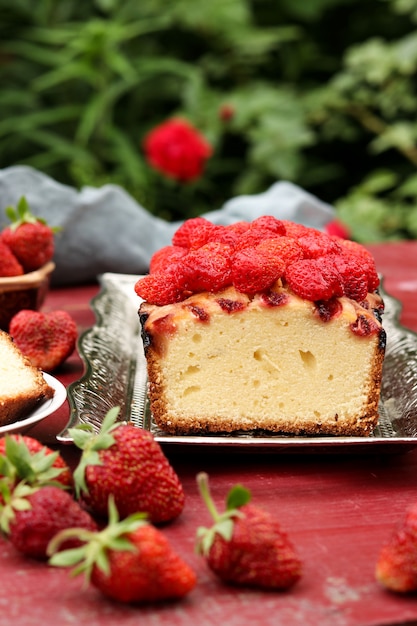 Cupcake with strawberries located on a table in the fresh air, on a metal tray