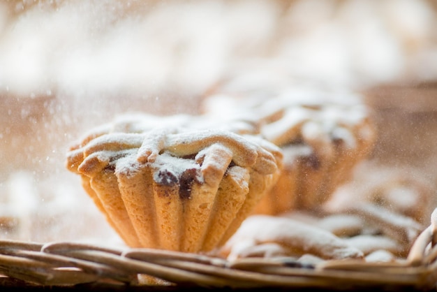 Cupcakes in a basket are crushed with powdered sugar
