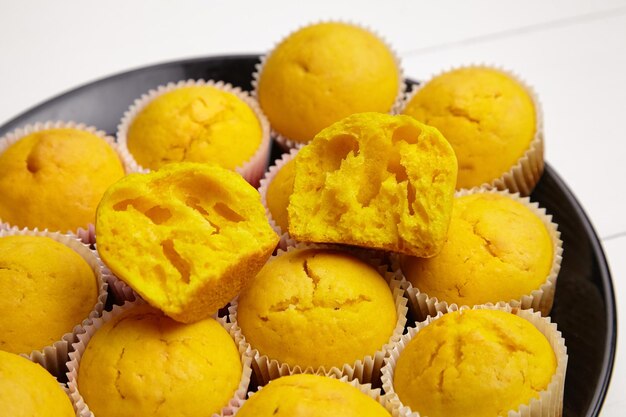 Cupcakes on black plate on white wooden table halved pumpkin muffin homemade bakery