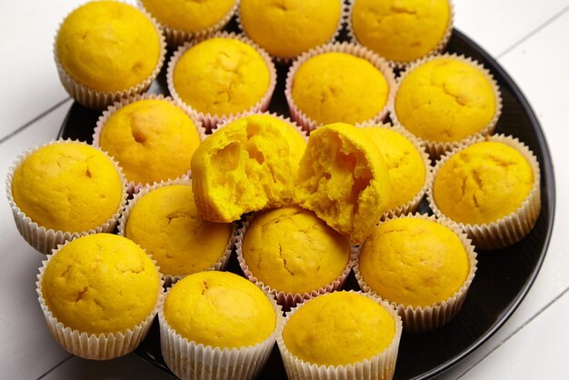 Cupcakes on black plate on white wooden table halved pumpkin muffin homemade bakery