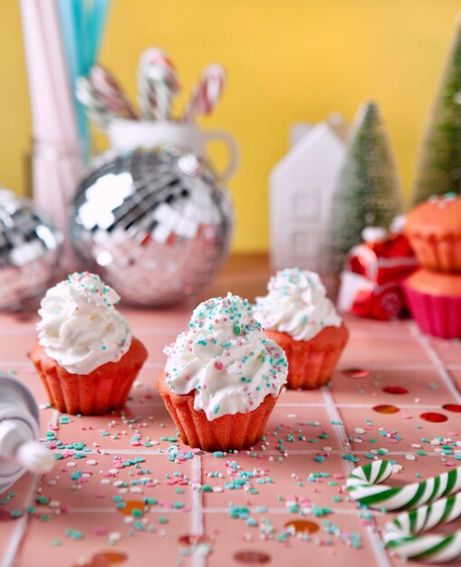 Cupcakes and christmas decorations on pink table retro style