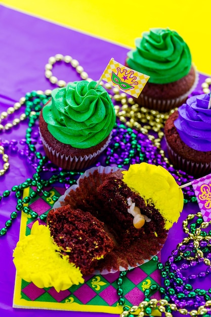 마디 그라 파티를 위해 밝은 색상의 아이싱으로 장식된 컵케이크.