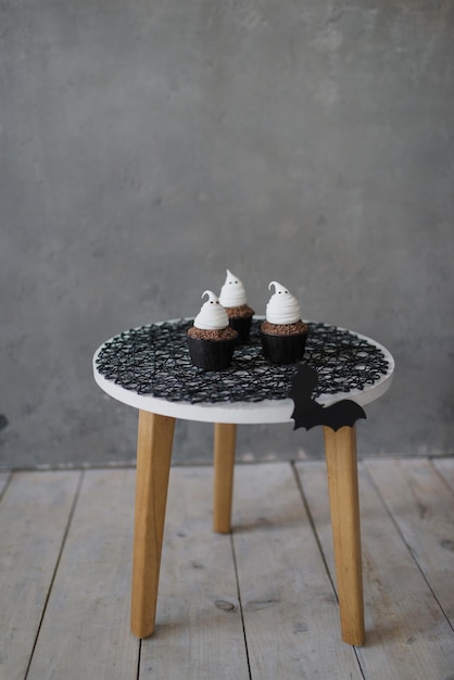 Cupcakes decorated with cute ghosts on a black background