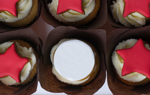 Cupcakes met room en rode sterren op een witte achtergrond.